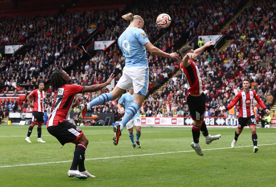 Manchester City striker Erling Haaland (2L) scores the opening goal