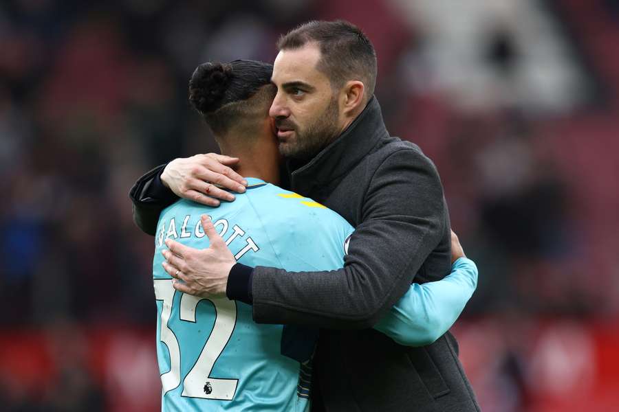 Southampton's Spanish head coach Ruben Selles (R) embraces Southampton's English midfielder Theo Walcott (L)