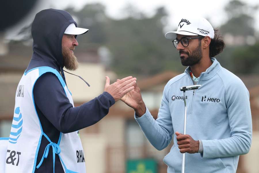 Akshay Bhatia (right) shakes hands with caddie Joe Greiner (left) on the 18th hole during the third round of the Pebble Beach Pro-Am