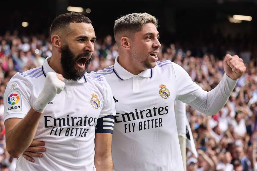 Real Madrid's French forward Karim Benzema celebrates with Uruguayan midfielder Federico Valverde