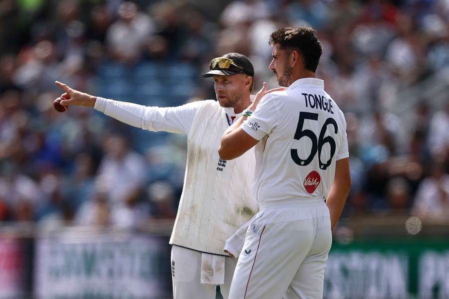 Tongue (R) alongside England captain Joe Root Tongue (R) alongside England captain Joe Root