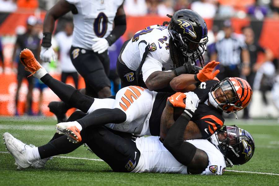 Ravens Jadeveon Clowney (24) en Patrick Queen (6) tackelen Cincinnati Bengals running back Joe Mixon (28) tijdens de eerste ontmoeting dit seizoen