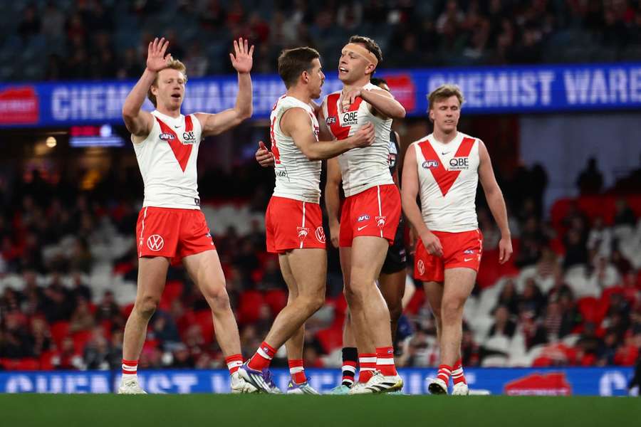 Will Hayward of the Sydney Swans celebrates a goal with his teammates.