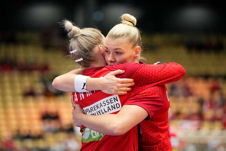 Denmark's Kathrine Heindal (R) and Sandra Toft hug each other before the World Championship quarter-final against Montenegro in 2023.
