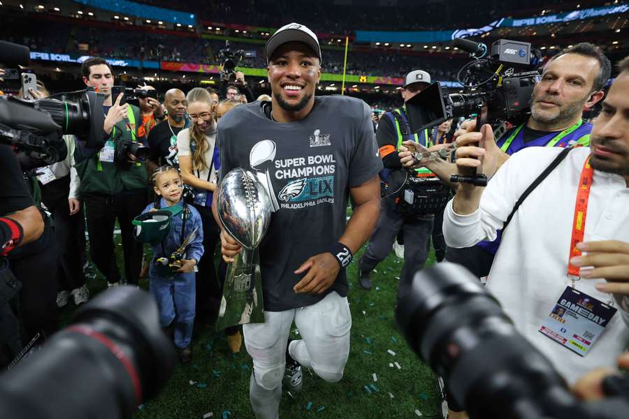 Philadelphia Eagles runningback Saquon Barkley walks off the field with the Lombardi Trophy (February 9, 2024)