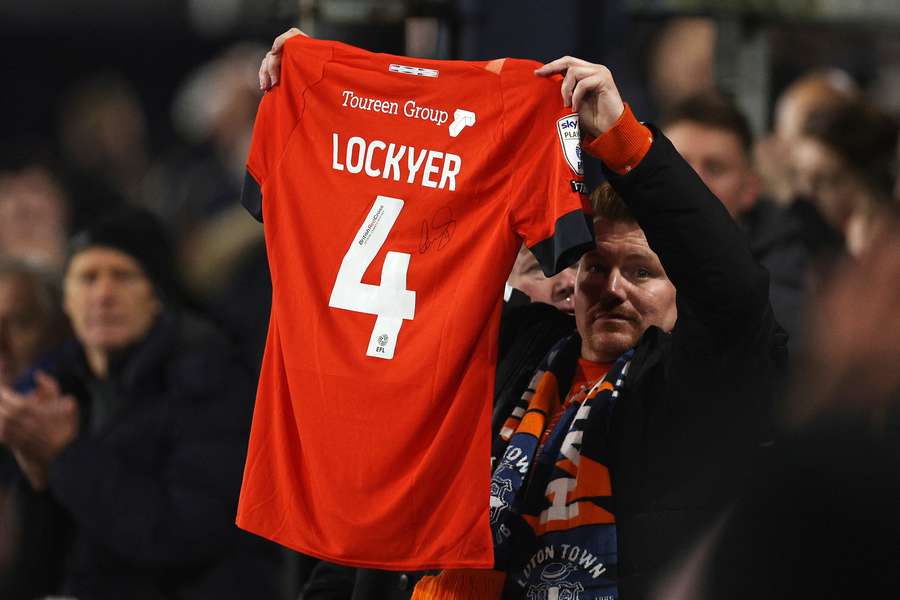 Un fan al lui Luton Town ridică un tricoul al lui Tom Lockyer