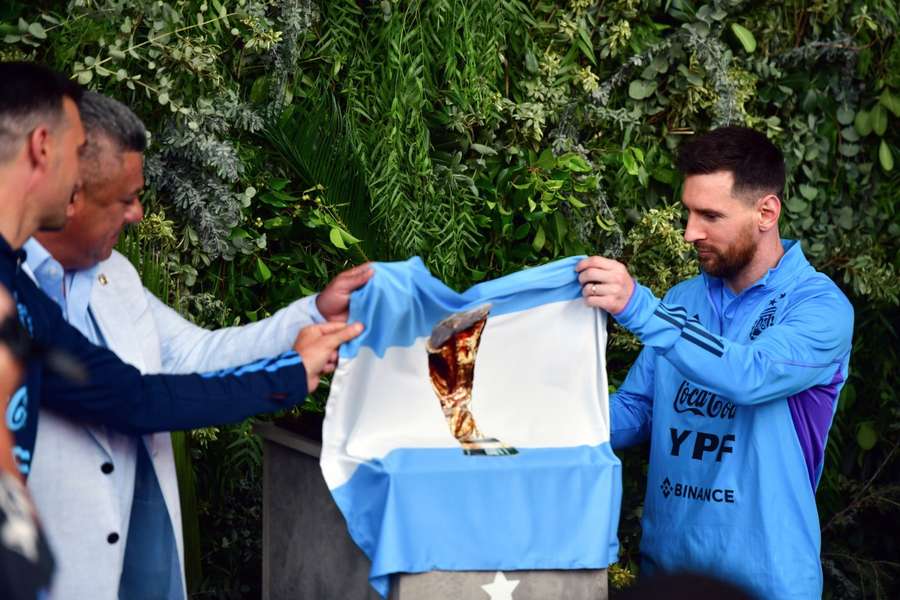 Argentine Football Association (AFA) president Claudio Tapia (2L) and Lionel Messi unveiling a plaque during the renaming of AFA's training camp