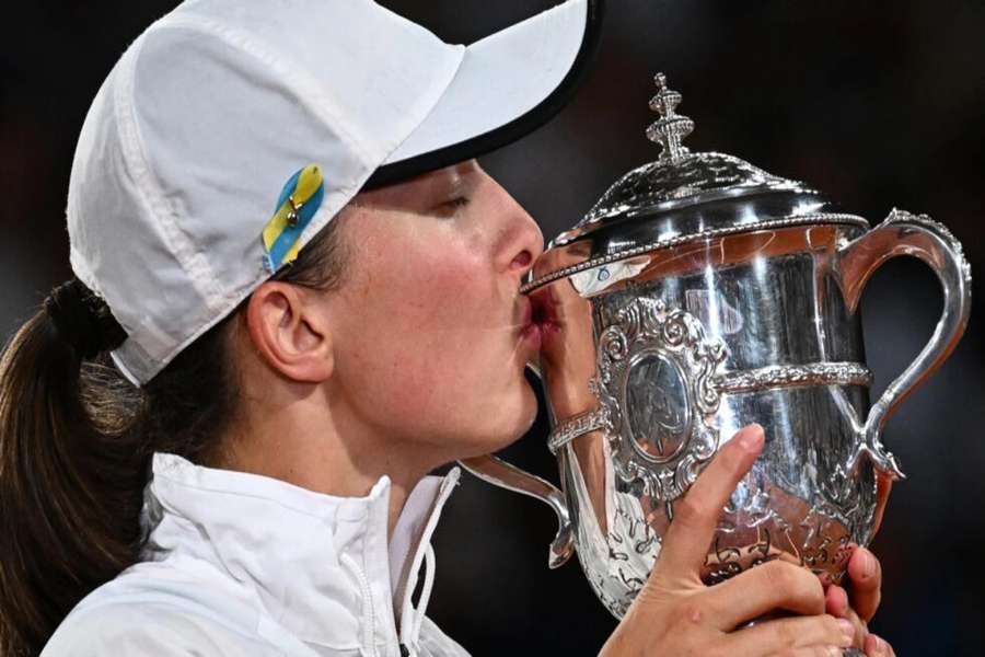 Champion: Iga Swiatek kisses the trophy after defeating Coco Gauff in the 2022 final