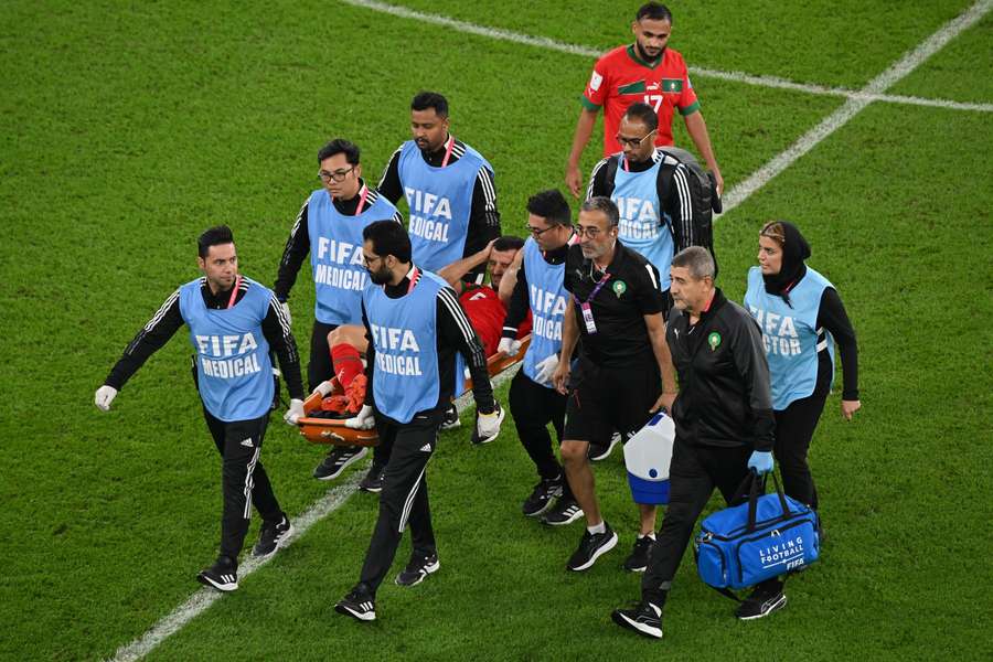 Romain Saïss gaat met een brancard van het veld af tegen Portugal