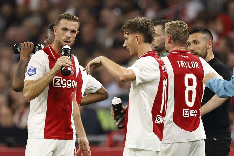 Jordan Henderson (L) draagt de aanvoerdersband bij Ajax