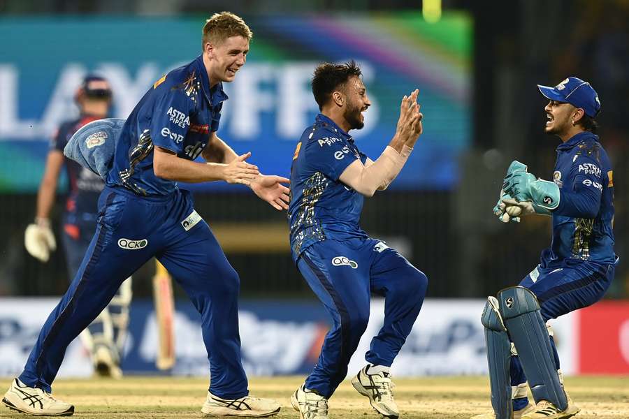Mumbai Indians' Akash Madhwal, centre, celebrates with teammates after the dismissal of Lucknow Super Giants' Nicholas Pooran