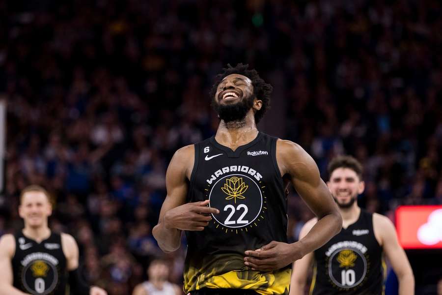 Andrew Wiggins sorri durante um jogo dos Warriors