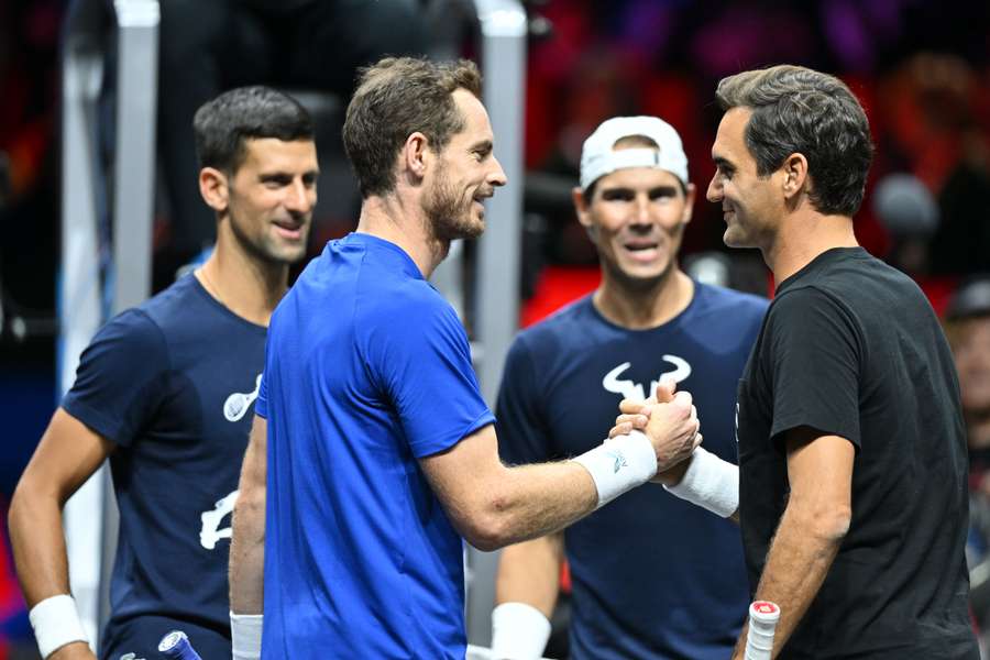 Andy Murray shakes hands with Roger Federer next to Novak Djokovic and Rafael Nadal (back R) during a practice session