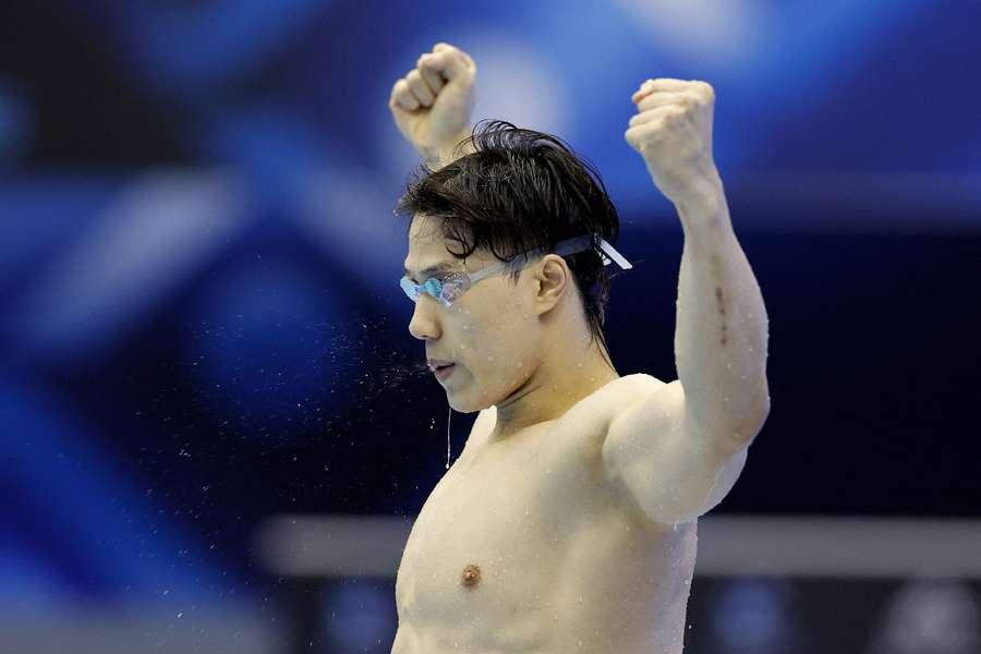 China's Qin Haiyang celebrates winning the men's 200m breaststroke final