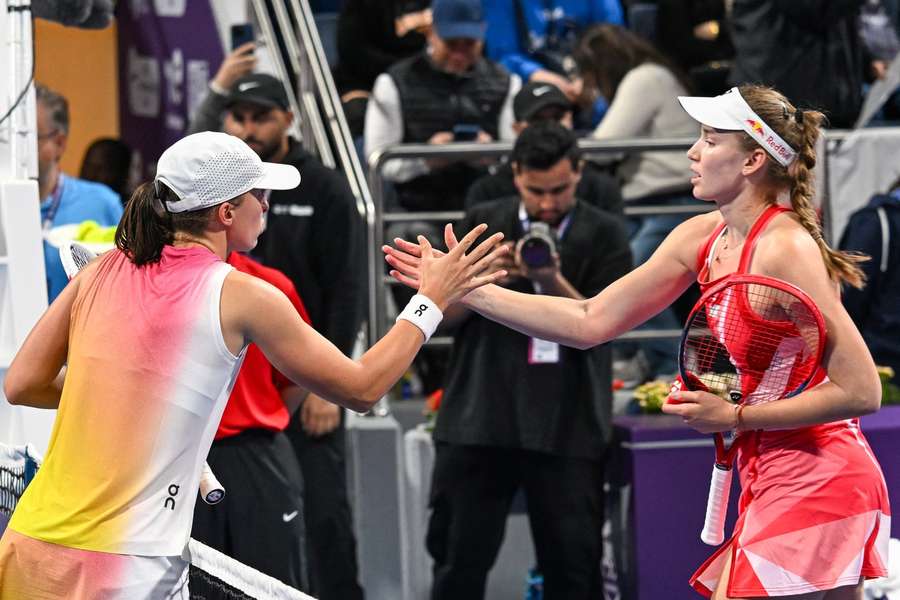 Swiatek and Rybakina shake hands at the net
