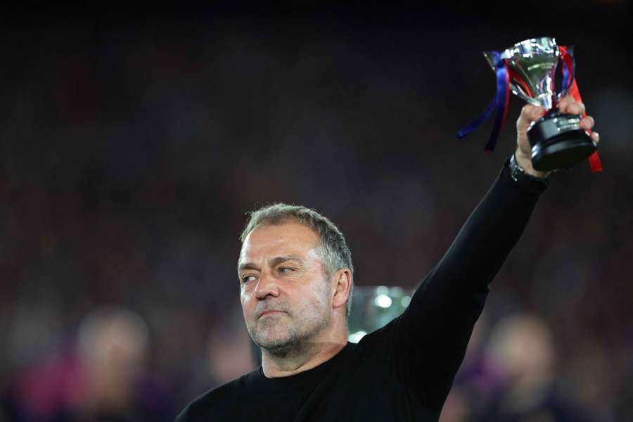 Barcelona coach Hansi Flick celebrates with a trophy after winning the LaLiga