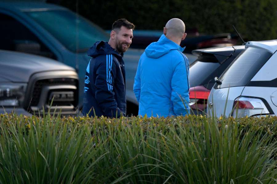 Messi (R) speaks to former Argentina defender Javier Mascherano