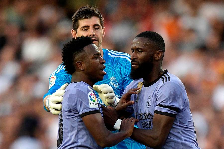 Vini Jr. é contido por companheiros de time durante jogo contra o Valencia