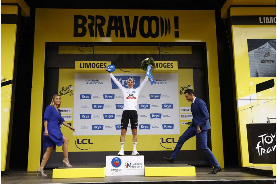 Pogacar celebrates on the podium wearing the white jersey after stage eight