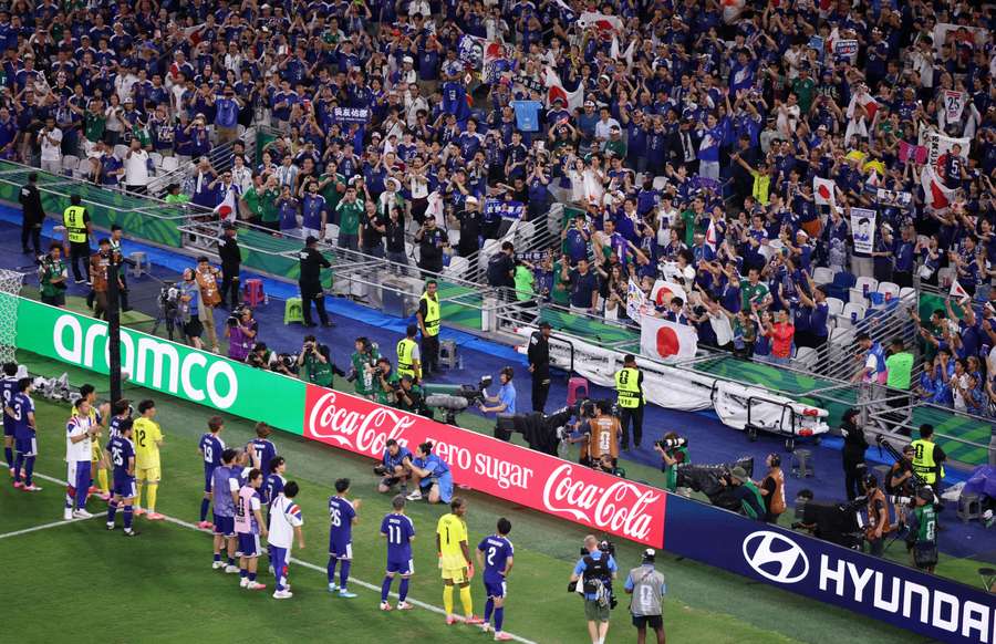 Japan players applaud fans after the match