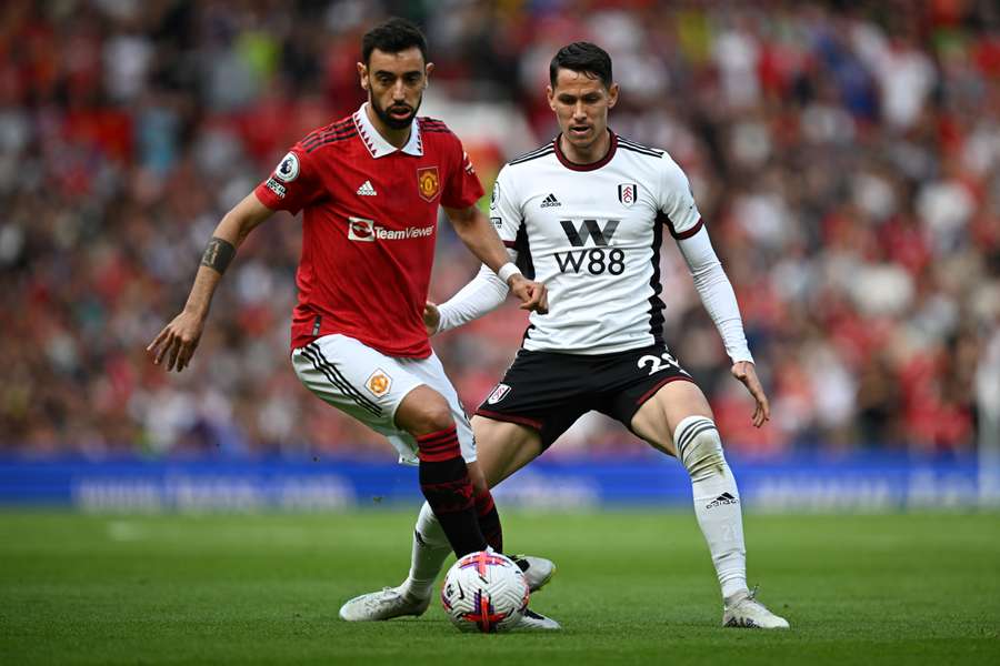 Manchester United's Portuguese midfielder Bruno Fernandes (L) fights for the ball with Fulham's Serbian midfielder Sasa Lukic