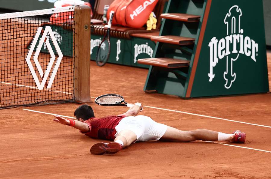 Novak Djokovic reacts after falling during the match