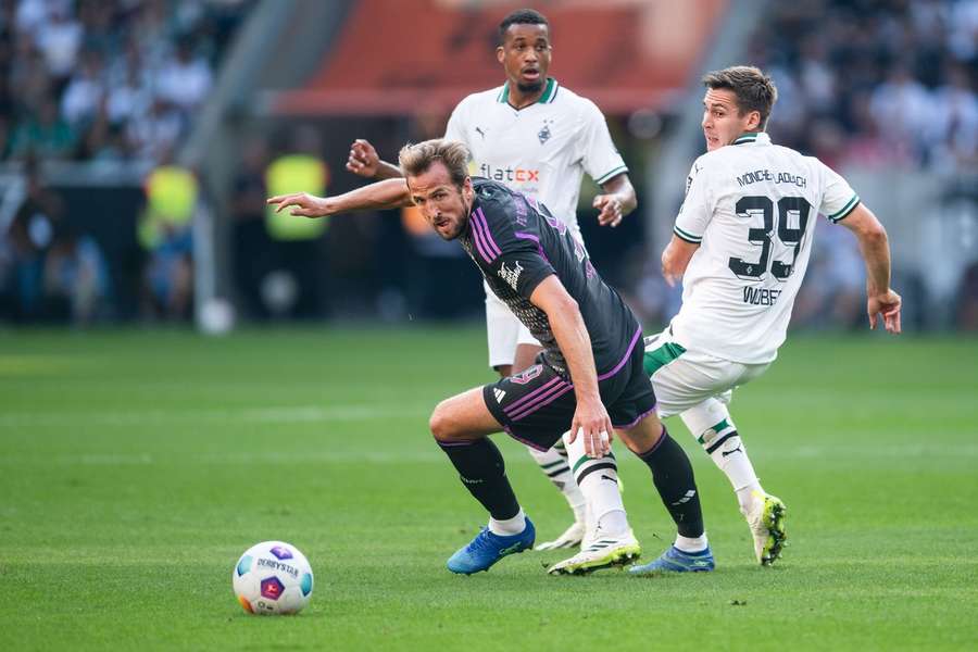 Kane fights for the ball with Wober and Plea