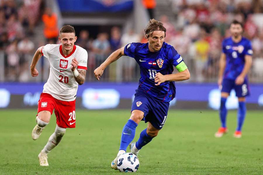 De Kroatische aanvoerder Luka Modric (R) aan de bal tegen Polen