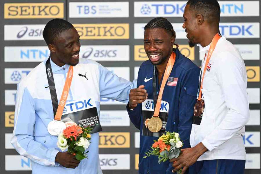 USA's gold medallist Noah Lyles is comforted by Botswana's silver medalist Letsile Tebogo and Britain's bronze medalist Zharnel Hughes