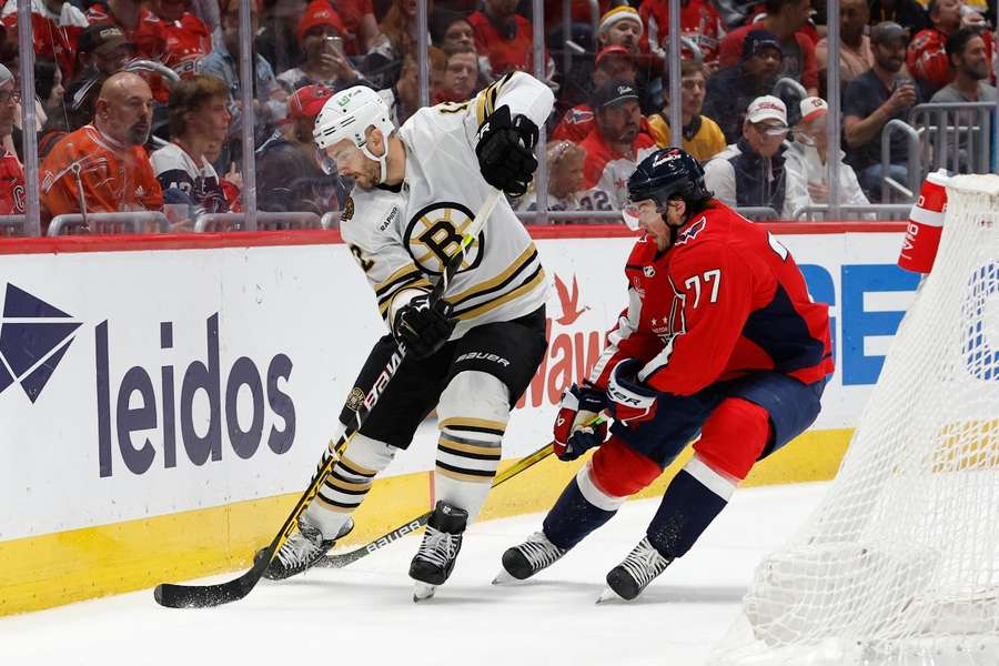 Boston Bruins defenceman Kevin Shattenkirk skates with the puck as Washington Capitals right wing T.J. Oshie defend