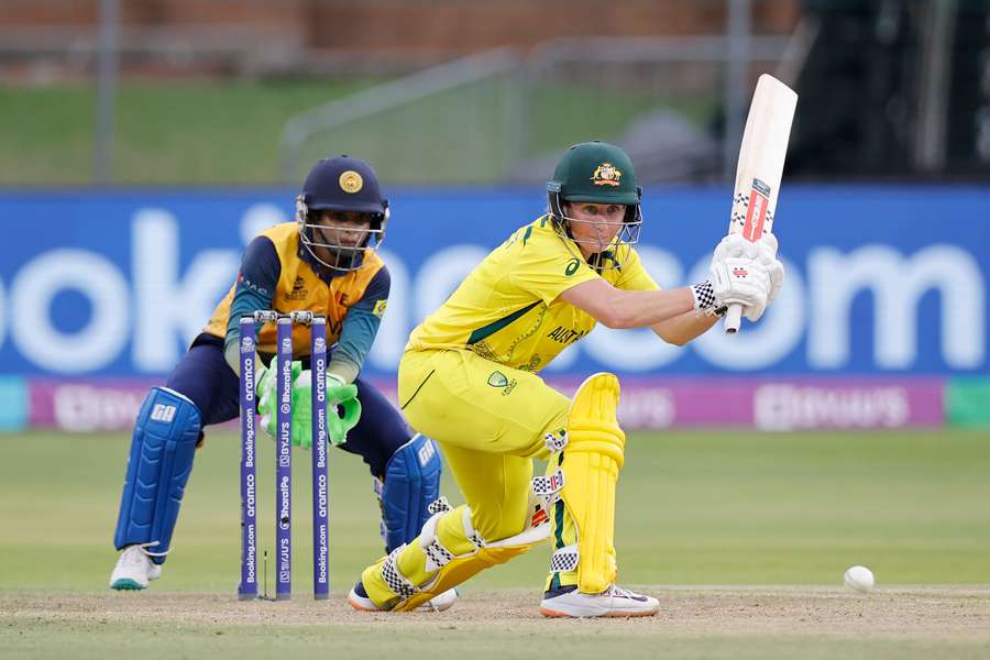 Australia's Beth Mooney (R) plays a shot as Sri Lanka's wicketkeeper Anushka Sanjeewani (L) looks on