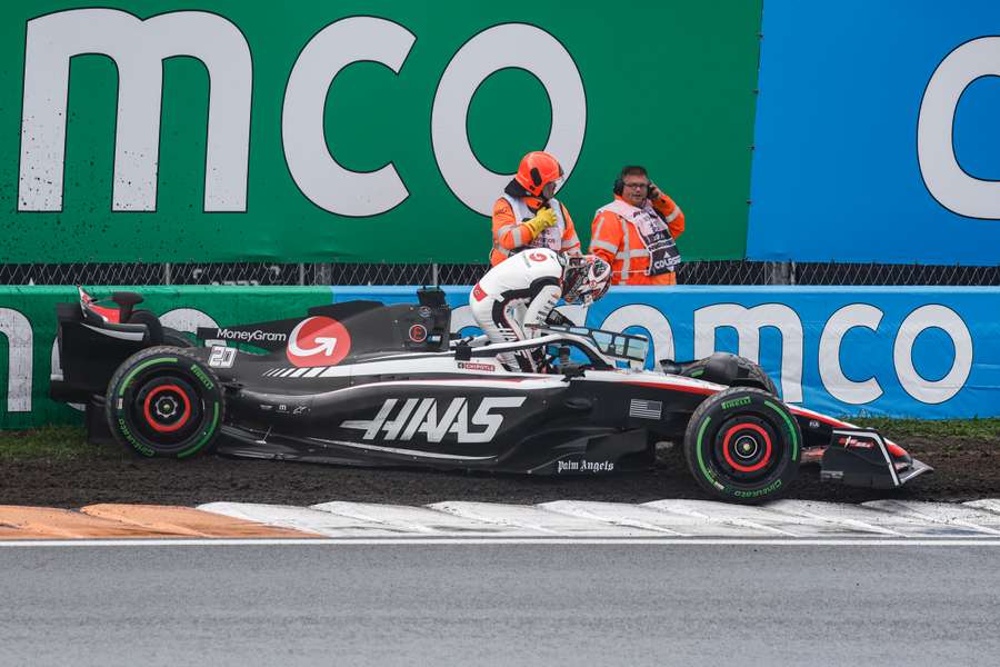 Haas' Kevin Magnussen (C) gets out of his car following a crash during the third practice session