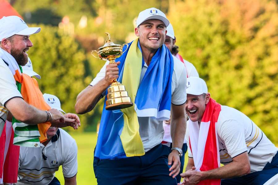 Ludvig Aberg holds the Ryder Cup draped in a Sweden flag