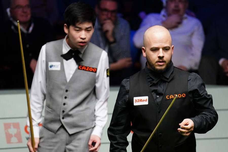 Jiahui Si looks on as Luca Brecel won five frames in a row to keep his championship hopes alive