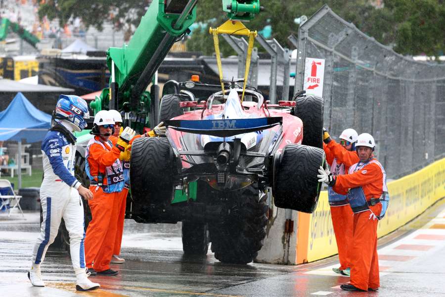 Los operarios retiran el coche con Leclerc mirando mientras se dirige a boxes