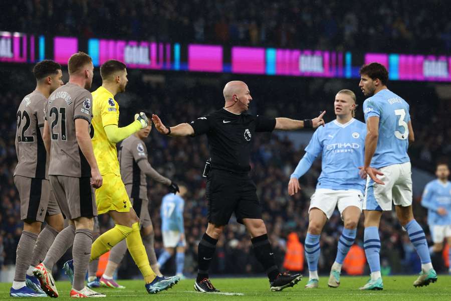 Players from both sides surround referee Simon Hooper (C)