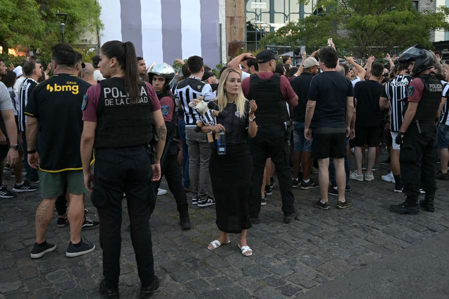 Adepta do Galo com uma mascote do clube pelas ruas de Buenos Aires
