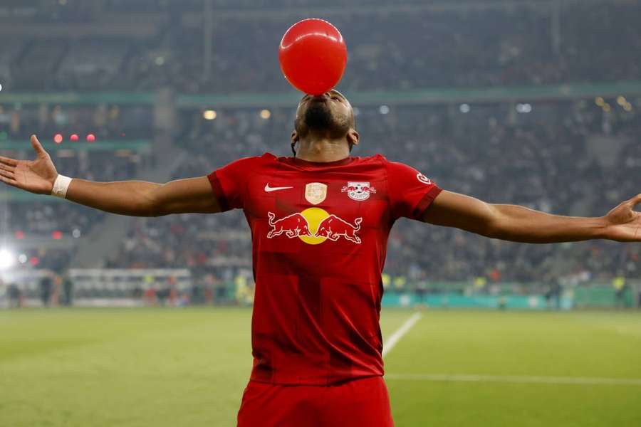 Leipzig's Christopher Nkunku blows up a balloon as he celebrates after opening the scoring