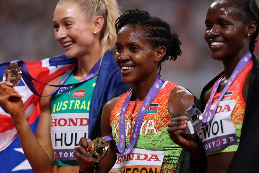Faith Kipyegon celebrates with her gold medal alongside silver medallist Dorcus Ewoi and bronze medallist Jessica Hull