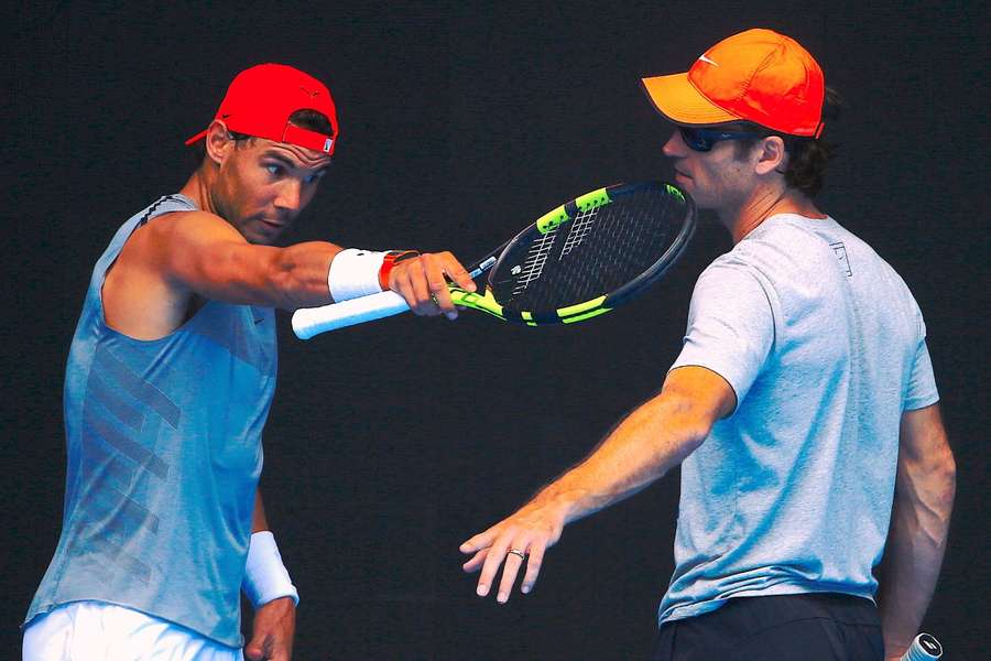 Rafael Nadal talks with his coach Carlos Moya during a practice session ahead of the Australian Open