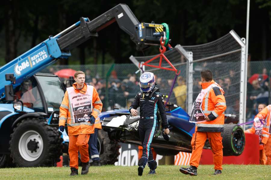 Williams' Logan Sargeant walks off as race marshals remove his car after he crashed during the practice session