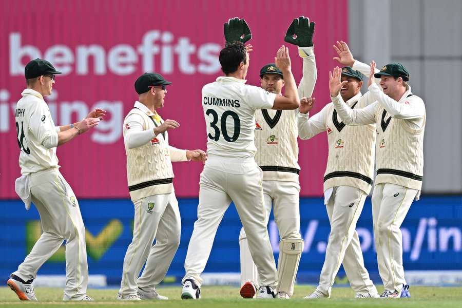 Pat Cummins celebrates with teammates after taking the wicket of Harry Brook as England closed on 68-3