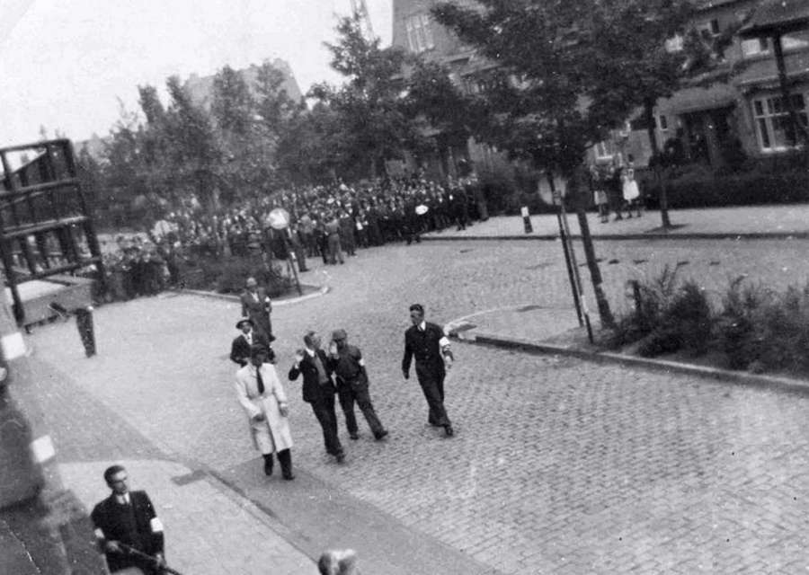 Ad van Eerd (2-R of group of four men) walks besides Adrianus Wolterbeek after his arrest by P.A.N. Ad van Eerd (2-R of group of four men) walks besides Adrianus Wolterbeek after his arrest by P.A.N.
