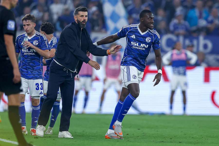 Schalke-Trainer Miron Muslic (M.) gratuliert Matchwinner Lasme (r.)