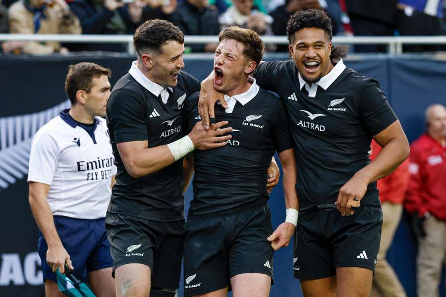 New Zealand's Cam Roigard (centre) celebrates with teammates after scoring against Ireland