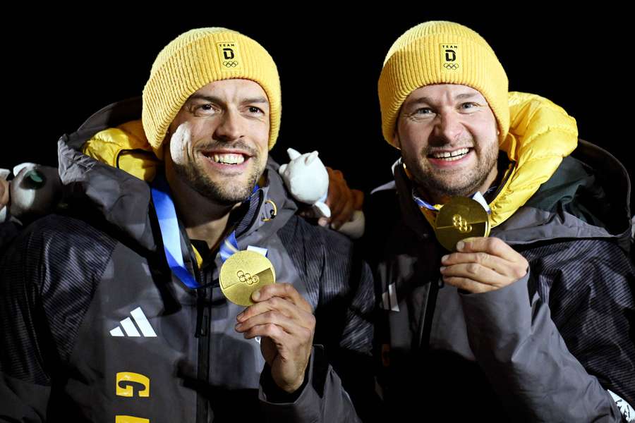 Gold medallists Johannes Lochner and Georg Fleischhauer of Germany celebrate on the podium during the bobsleigh two-man victory ceremony