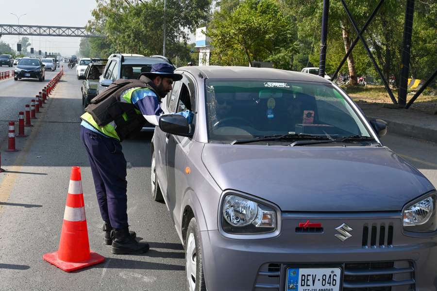 A policeman inspects a car at a checkpoint in Islamabad, Pakistan. A policeman inspects a car at a checkpoint in Islamabad, Pakistan.