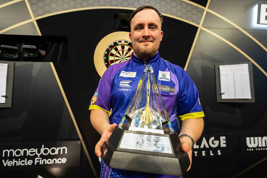 Luke Littler poses with the Premier League Darts trophy in 2024