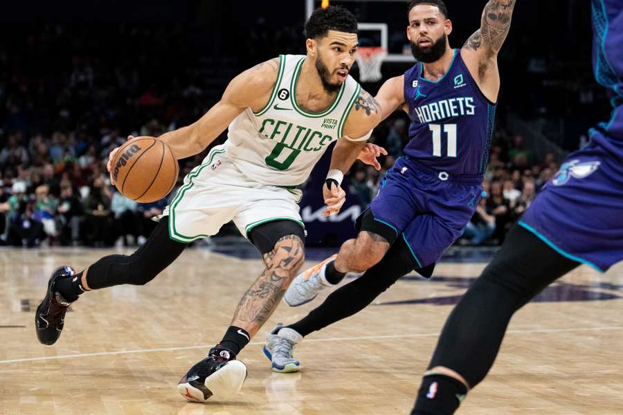 Jayson Tatum #0 of the Boston Celtics drives to the basket while guarded by Cody Martin #11 of the Charlotte Hornets