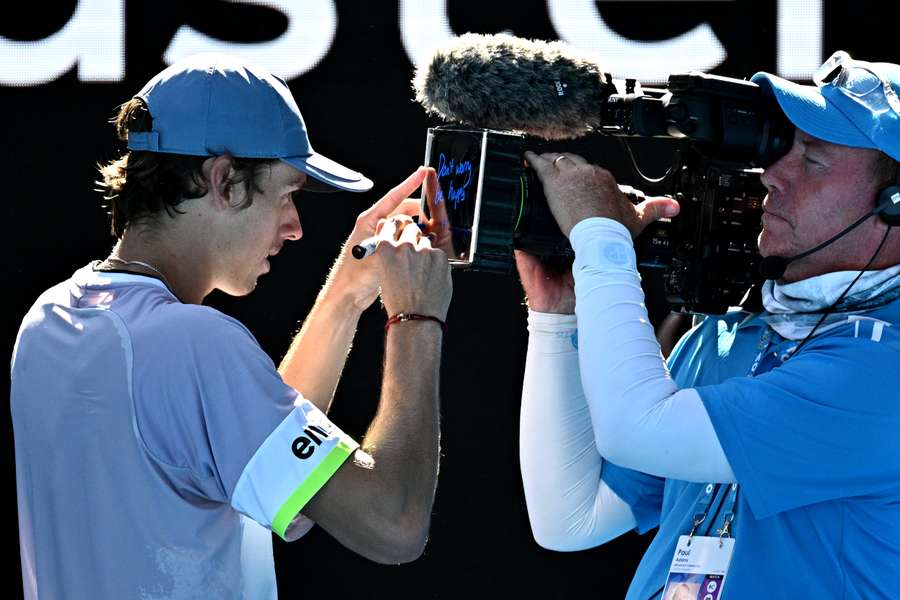 De Minaur signs the camera after his win against Bonzi